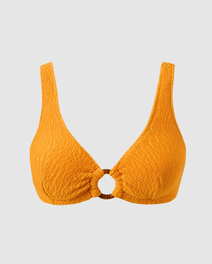An bikini top with a ring cut-out in apricot orange.